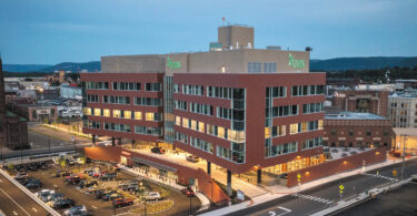 red brick building with lights on at dusk