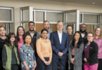 Multiple hospital employees pose for a group photo at the new UHS Upper Front Street facility.