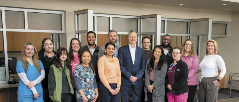 Multiple hospital employees pose for a group photo at the new UHS Upper Front Street facility.